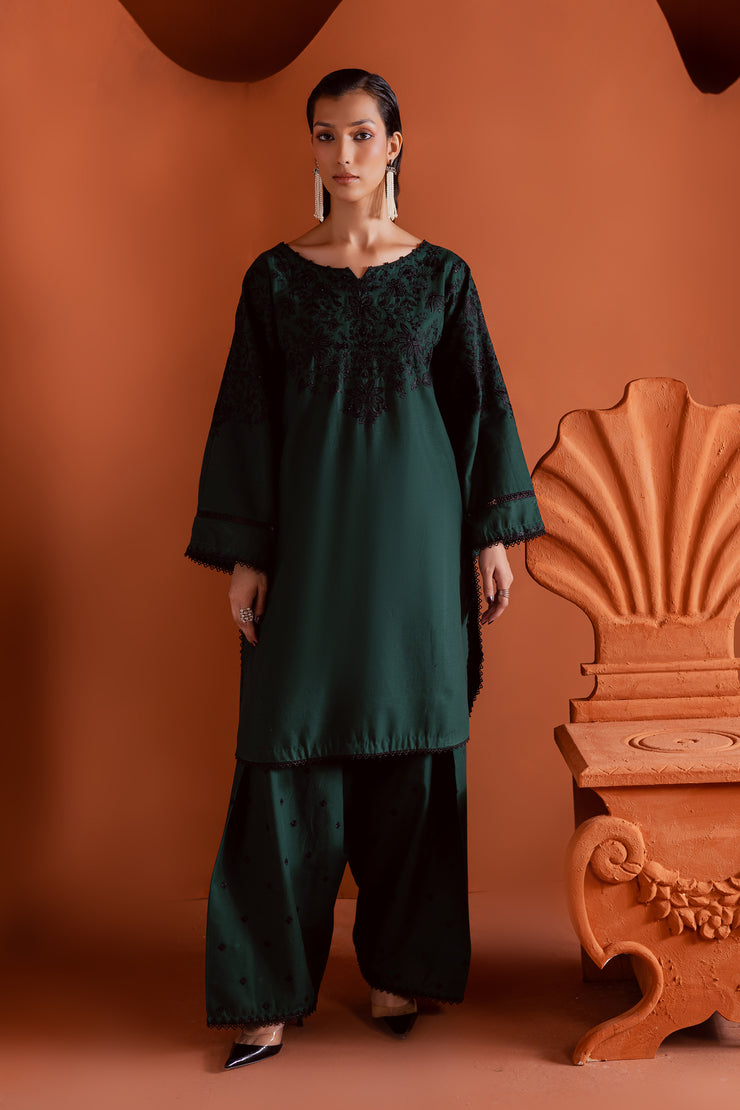 Batik Dippit two piece khaddar set featuring an emerald green short kurta with black embroidery and hand embellishments. Affordable ethnic Pakistani South Asian.
