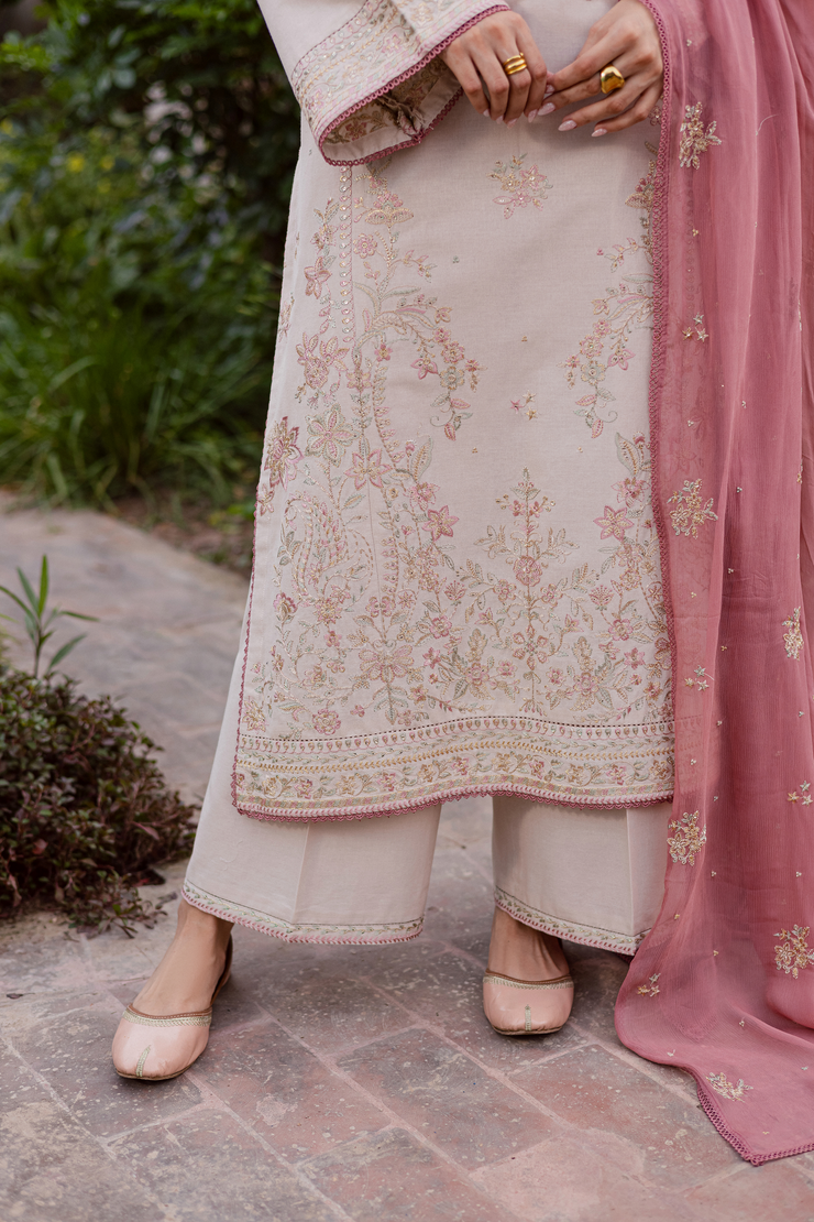 Elegant embroidered khaddar set crafted with intricate beadwork and soft pastel hues. Ready to wear Pakistani South Asian.