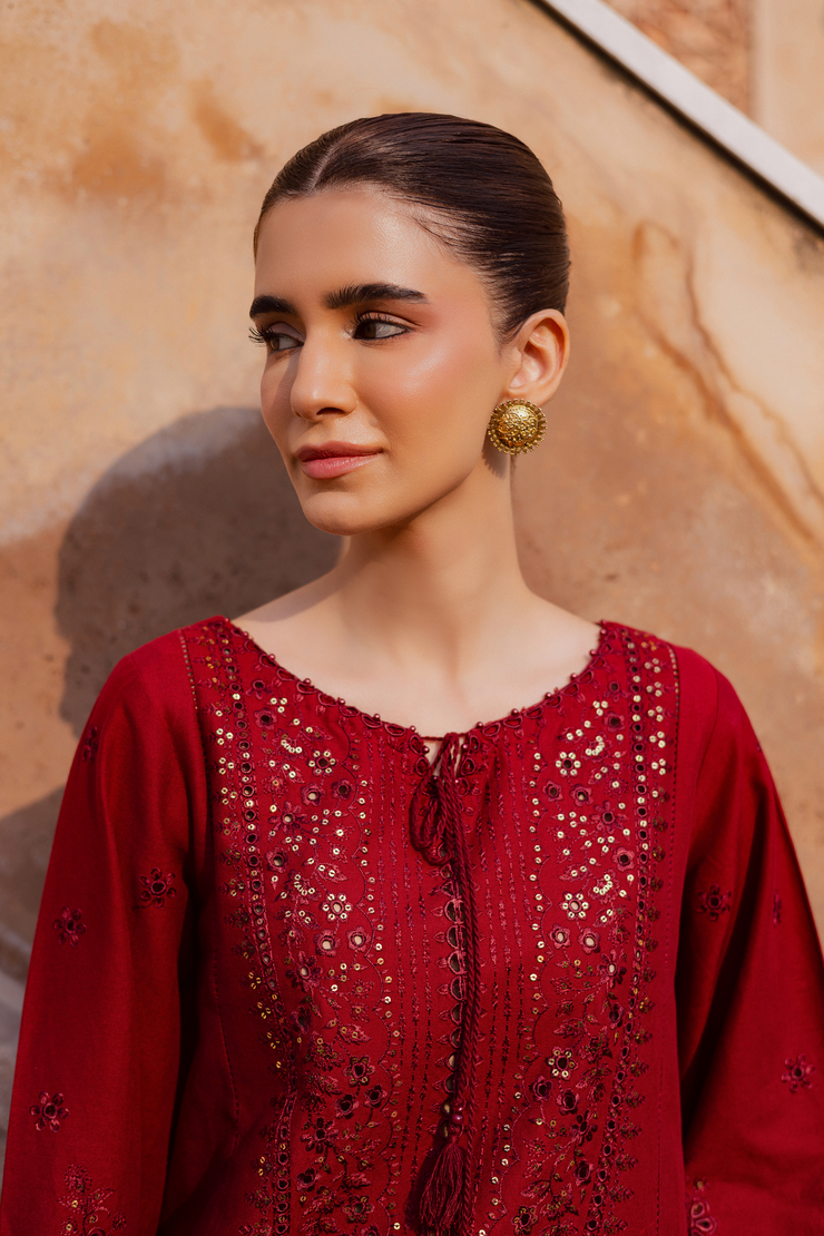 Embroidered red khaddar shirt adorned with tassel embellishments and delicate work. Ready to wear Pakistani South Asian.