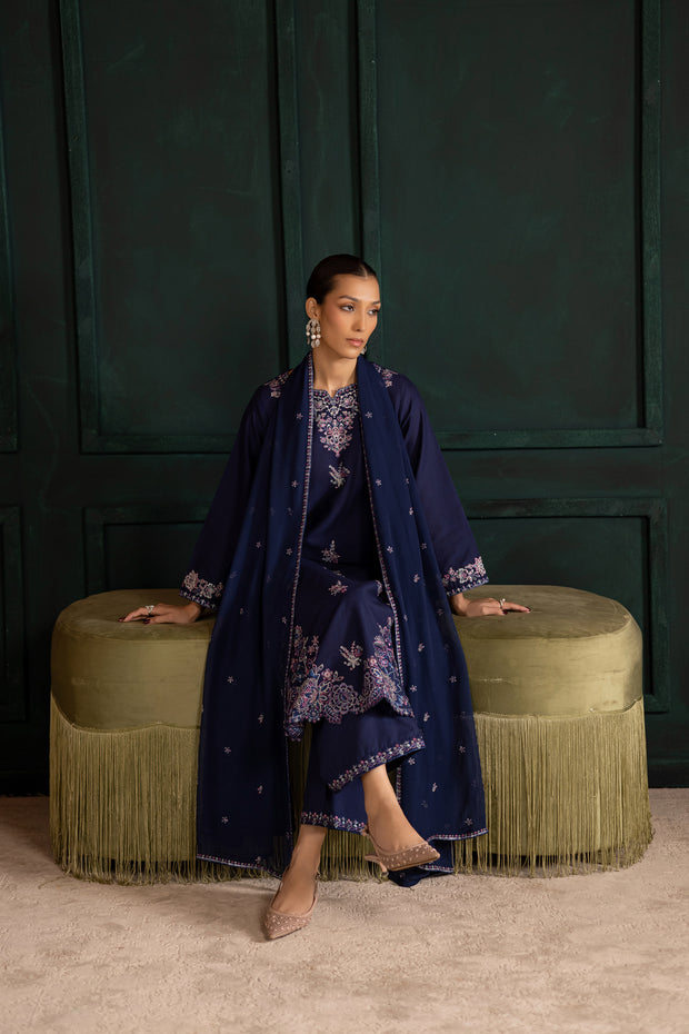 Model wearing Dusky blue khaddar set paired with a flowing dupatta for a festive elegant look. Ready to wear Pakistani South Asian.