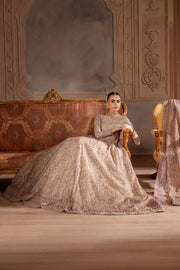 Wide shot of bride in full flare gown seated on a vintage sofa, creating a royal South Asian bridal aesthetic. Bridal luxury Pakistani South Asian Indian.