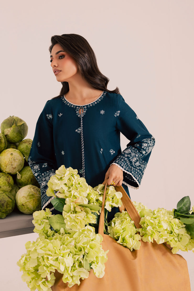 Two piece khaddar set featuring intricate embroidery and tassel accents for understated luxury. Ready to wear Pakistani South Asian.